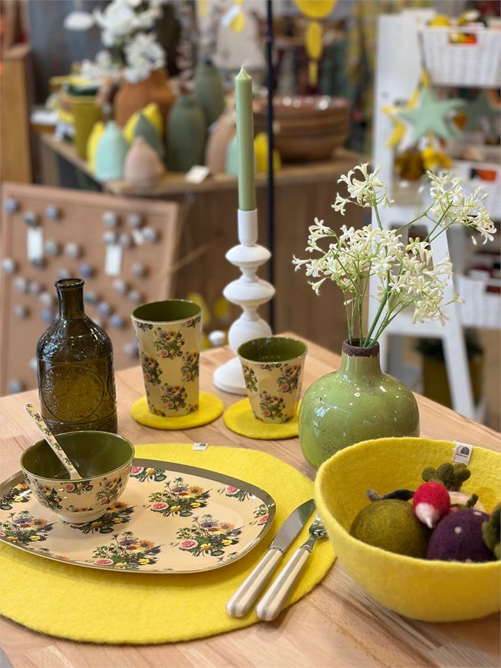 Composition de table mêlant vaisselle, verre, feutre et fleurs